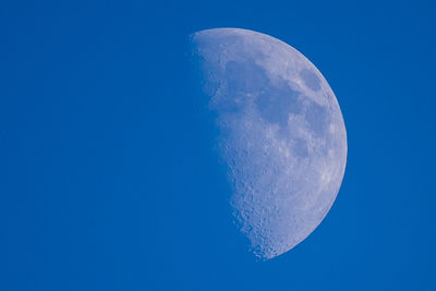 Low angle view of moon against clear blue sky