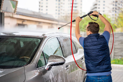 Rear view of woman holding car