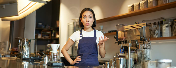 Portrait of young woman standing in cafe