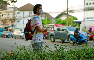 Man wearing flu mask standing outdoors