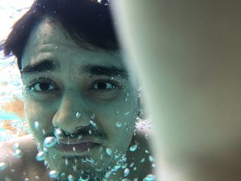 Close-up portrait of young woman in water