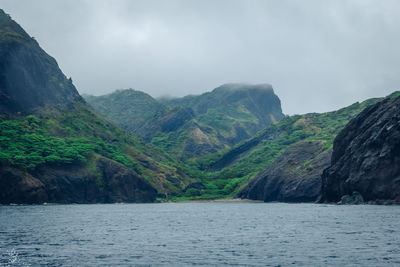 Scenic view of sea and mountains against sky