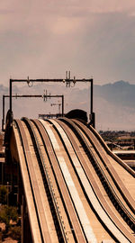 Train on railroad tracks against sky during sunset