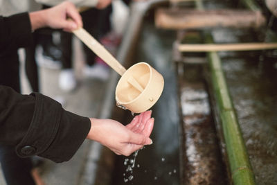 Midsection of man holding ice cream on wood