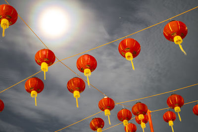 Low angle view of lanterns hanging against sky