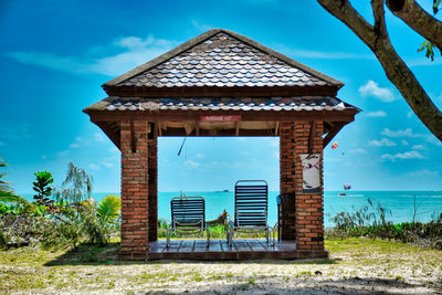 Built structure on beach against blue sky