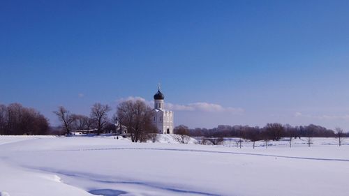 Scenic view of snow covered trees against clear blue sky