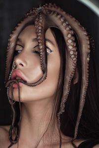 Close-up of young woman with octopus on head