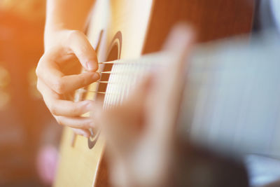 Midsection of person playing guitar