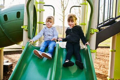 Full length of a smiling girl sitting outdoors