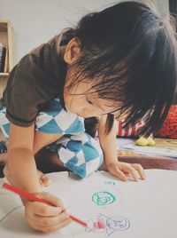 Rear view of cute girl sitting at home
