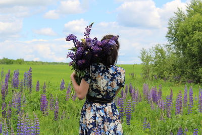 Woman with flowers on field