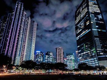 Illuminated buildings in city against sky at night