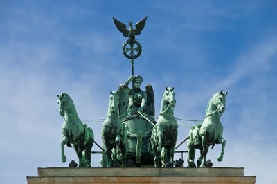 Low angle view of quadriga statue on brandenburg gate against sky