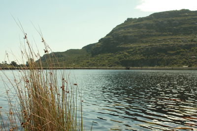 Scenic view of lake by mountains against sky