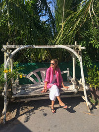 Full length of woman standing by palm trees