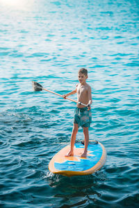 Full length of shirtless boy in sea