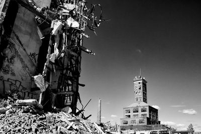 Demolished building and residential building against sky