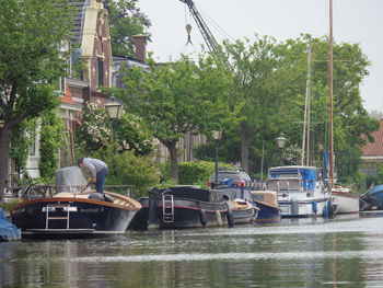 Boats moored in river against trees