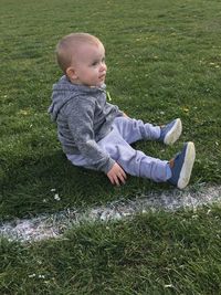 Full length of toddler sitting on grassy field