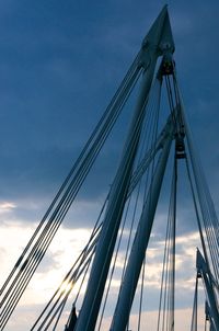 Low angle view of suspension bridge against blue sky