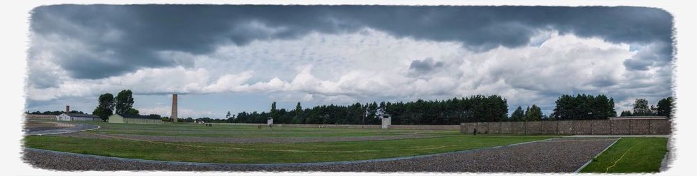 Scenic view of grassy field against cloudy sky