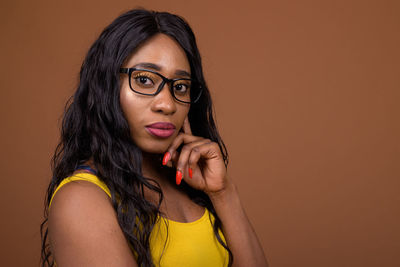 Portrait of beautiful young woman against gray background