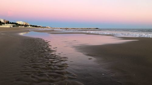 Scenic view of beach against sky during sunset