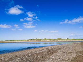 Scenic view of beach against blue sky