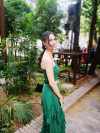 Portrait of woman smiling while standing at park