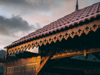 Low angle view of malay architectural wooden roof against dusk sky