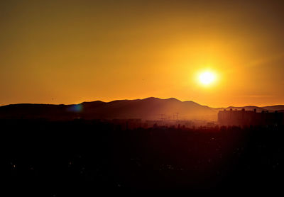 Scenic view of silhouette mountains against romantic sky at sunset