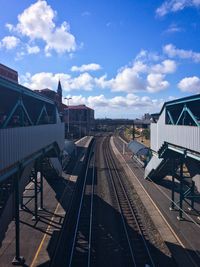 Railroad tracks against cloudy sky