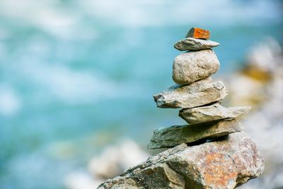 Close-up of stone stack on rock against sea