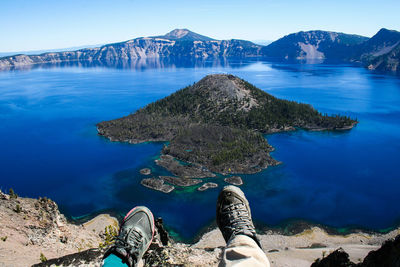 Low section of person against crater lake