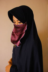 Portrait of woman standing against wall