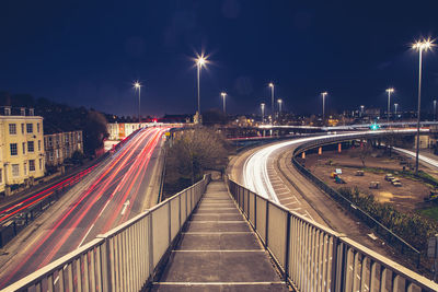 Light trails on road against sky at night