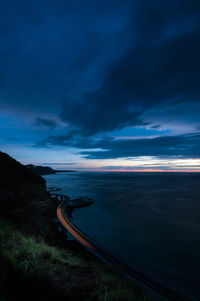 Scenic view of sea against cloudy sky at night