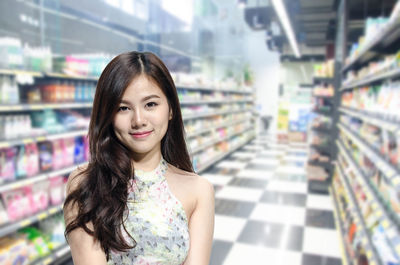 Portrait of smiling young woman standing in store