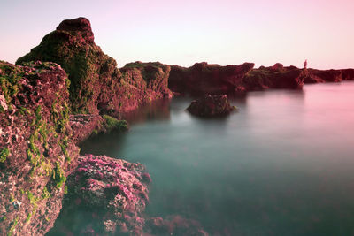 Rock formations in sea against sky