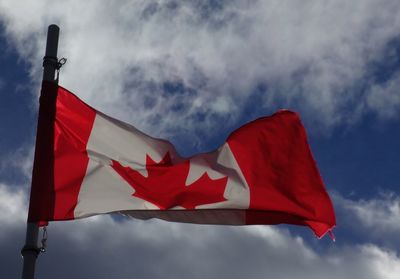 Low angle view of american flag against cloudy sky