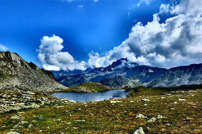 Scenic view of lake by mountains against sky