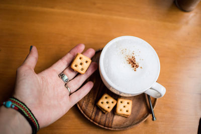 Midsection of woman holding coffee cup on table