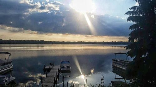 Sun shining through clouds over water