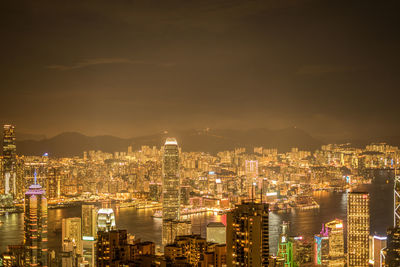 Illuminated cityscape against sky at night