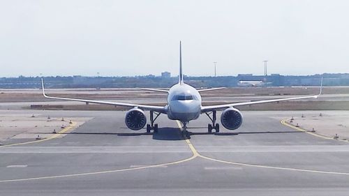 Airplane on runway against sky