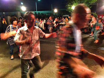 Rear view of people enjoying at night