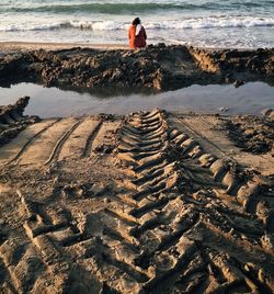 Rear view of woman relaxing on seashore