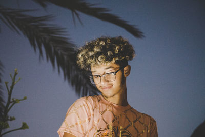 Smiling young man against sky at dusk