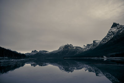 Scenic view of lake by mountains against sky